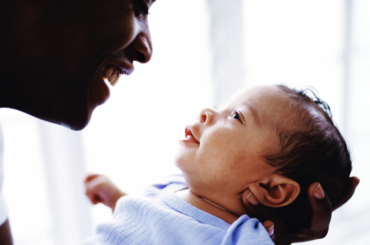 Parent looking at their smiling new born.