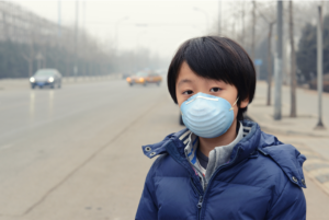 Child breathing through a surgical mask.