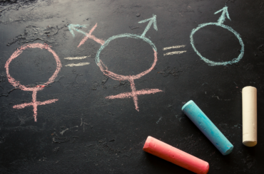Red, blue and white colored chalk drawings of the female, male symbols and a third which is a combination of the two.