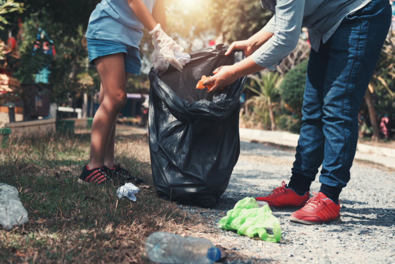 Parent and child picking up trash at the park.