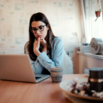 Worried woman looking at laptop.