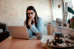 Worried woman looking at laptop.