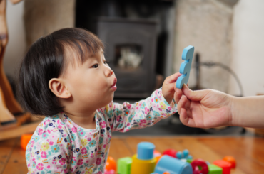 Baby playing with an adult.