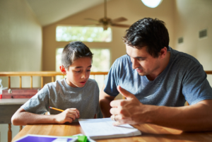 Father and son working on school assignment.