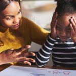 Mother helping frustrated daughter with school work.