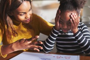 Mother helping frustrated daughter with school work.