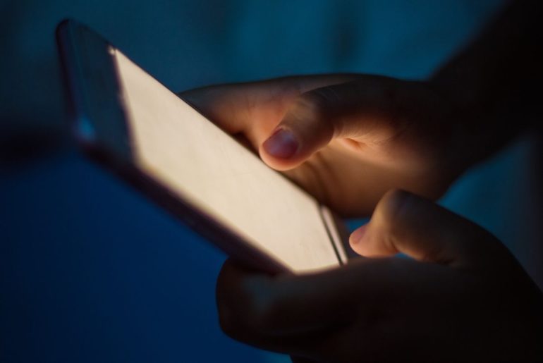 Close up on child's hands using a smartphone.