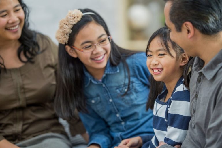 Family sitting close and laughing together.