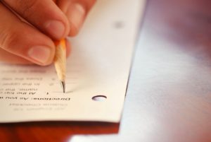 Close up of hand taking test with pencil.