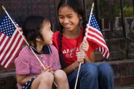 Smiling girls holding American flags.