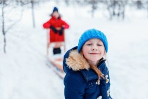 Kids playing happily in the snow.