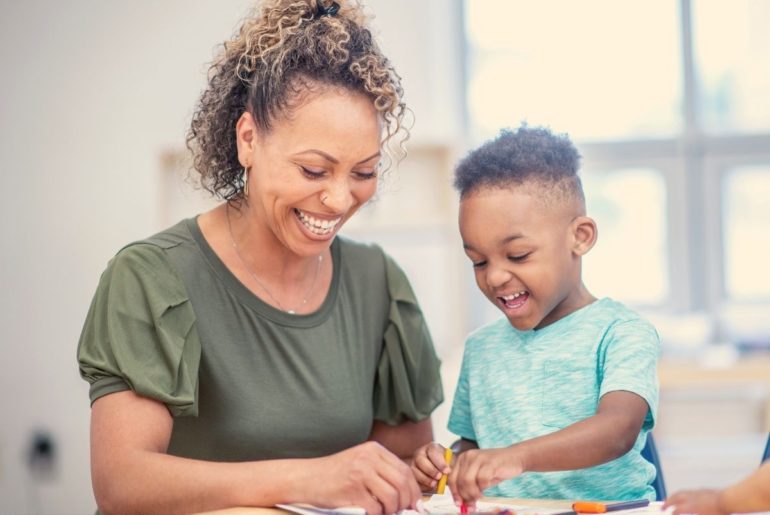 Mother and son laughing while working on a craft project.