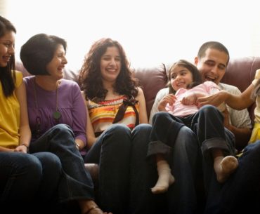 Family laughing on couch.