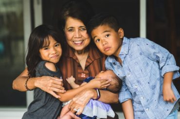 Grandmother holding three grandkids.