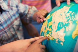 Kids pointing to globe.