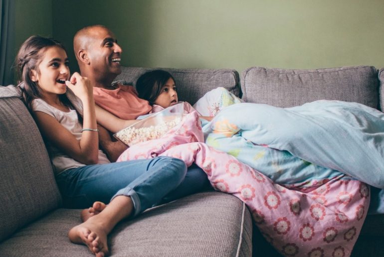 Father and kids enjoying family movie night.