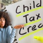 Woman shrugging over Child Tax Credit writing on notebook in background.