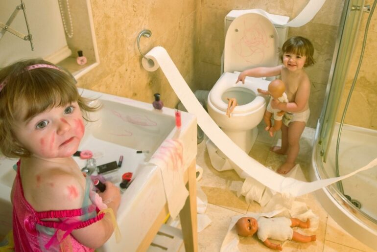 Twin toddlers making a huge mess in the bathroom.