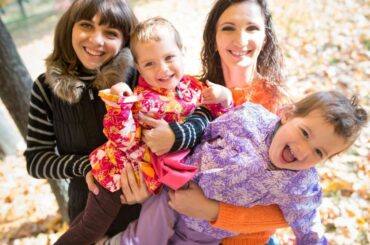 Two mom friends and their young kids in a park.