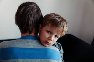 Father hugging sad boy.