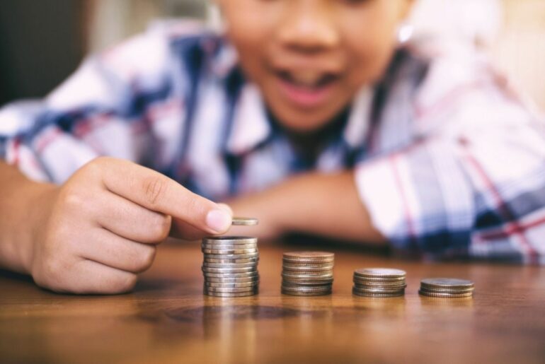 Boy counting coins in the foreground.