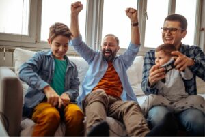 Parents celebrating on couch with two kids.