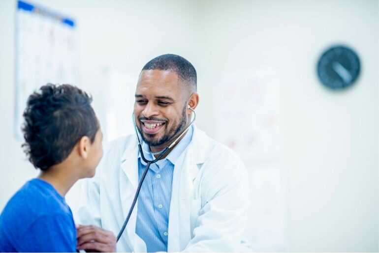 Smiling doctor giving boy a checkup.