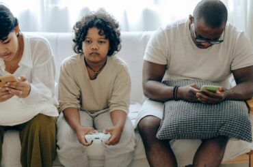 Family on couch using devices.