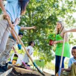 Teacher and students plant vegetables in school garden.