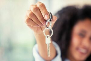 Woman proudly holding up key.