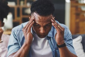 Overwhelmed man holding his temples.