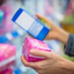 Close up of woman's hands at store holding period products.