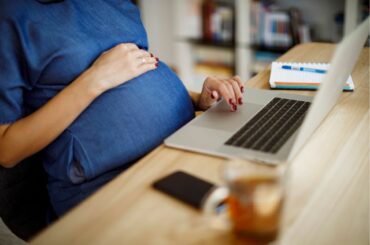 Pregnant worker sitting at desk.