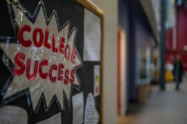 Red letters spelling out "College success" on a bulletin board in a school hallway