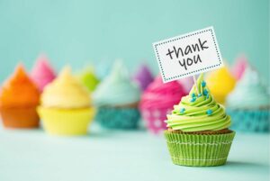 Cupcakes in many colors and one with a banner that reads "Thank you."