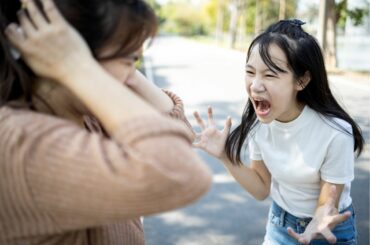 Angry child screaming at mother, who is covering her ears. Featured image for ParentsTogether's article about how to deal with kids' tantrums, anger and aggression.