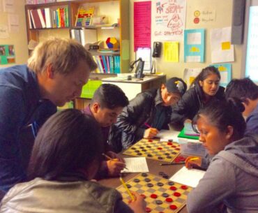 Oakland International High math teacher David Hansen teaches newcomer immigrant students fractions using the game of checkers