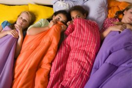 Four tweens lay in sleeping bags during a sleepover