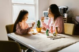 Mom and daughter painting pottery together