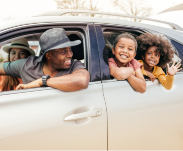 Family in car heading out on road trip