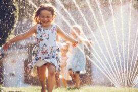Kid running through sprinkler