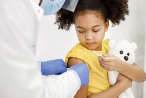 Kid getting bandaid after vaccine