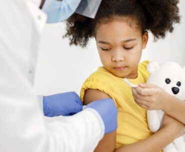 Kid getting bandaid after vaccine