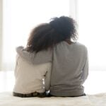 Supportive parent with arm around teen