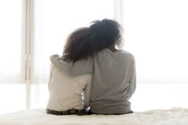 Supportive parent with arm around teen