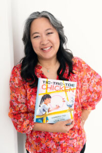 Author Kimberly Tso holding her book Tic-Tac-Toe Chicken