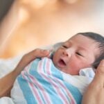 Newborn baby swaddled in hospital blanket