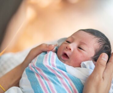 Newborn baby swaddled in hospital blanket