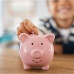 Child saving money in piggybank