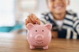 Child saving money in piggybank